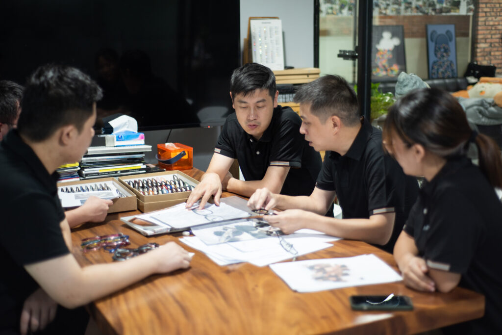 Eyewear development team reviewing frame drawings and samples